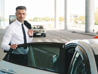 smiling-mature-businessman-getting-in-taxi-outside-1024x682