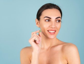 close-up-beauty-portrait-topless-woman-with-perfect-skin-natural-make-up-holding-supplement-vitamin-omega-3-fish-oil-turquoise-background_343596-7823