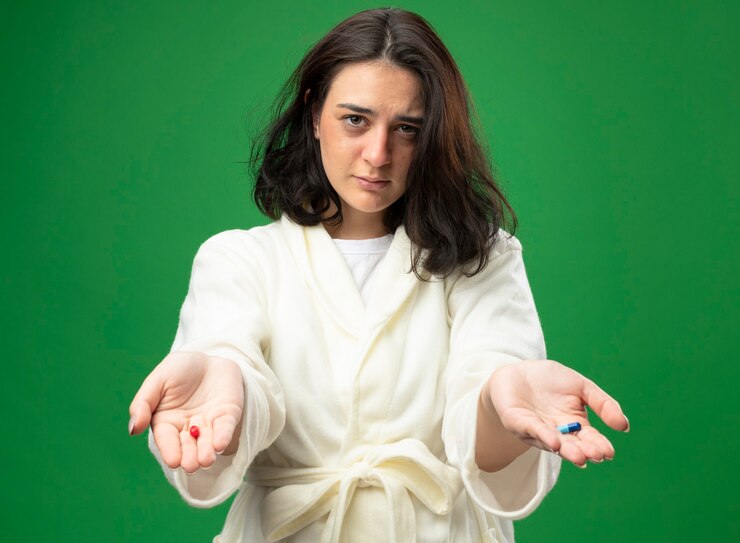 confident-young-caucasian-ill-girl-wearing-robe-stretching-out-medical-capsules-towards-camera-looking-camera-isolated-green-background_141793-78083