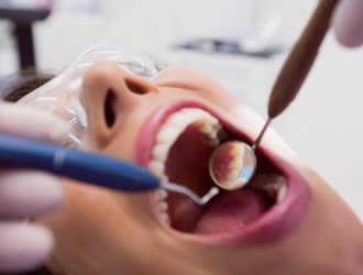 dentist-examining-female-patient-with-tools_107420-65513