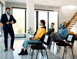 businessman-with-protective-face-mask-giving-presentation-seminar-board-room_637285-10725