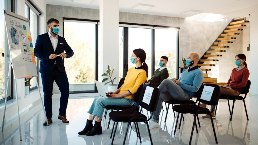 businessman-with-protective-face-mask-giving-presentation-seminar-board-room_637285-10725