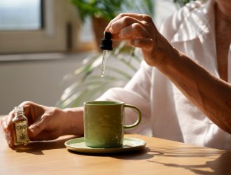 close-up-woman-putting-cbd-oil-drink_23-2150830186