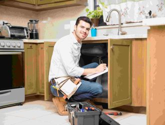 portrait-attractive-hispanic-handyman-writing-work-estimate-before-fixing-kitchen-sink-compressed