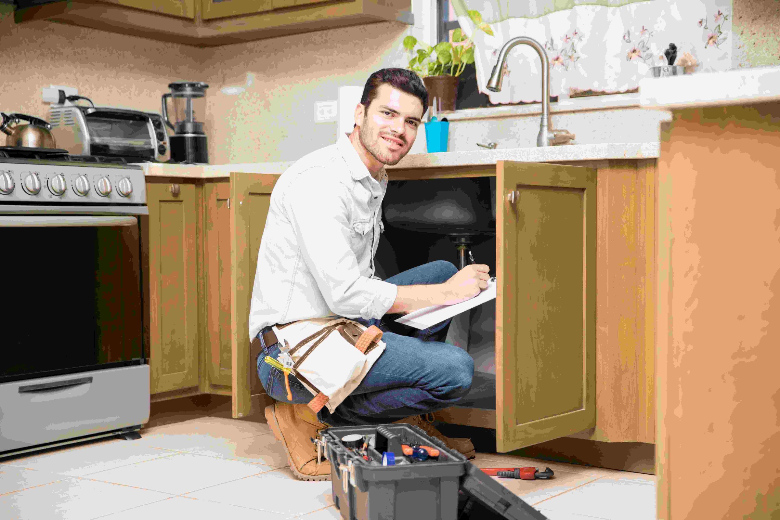 portrait-attractive-hispanic-handyman-writing-work-estimate-before-fixing-kitchen-sink-compressed