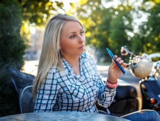 girl-with-long-blond-hair-tshirt-sitting-table-outside-smoking-electronic-cigarette_613910-15452 (1)