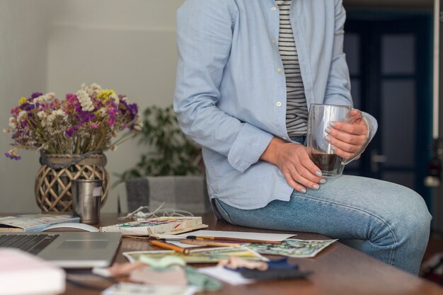 unrecognisable-woman-sitting-messy-desk_23-2148372131